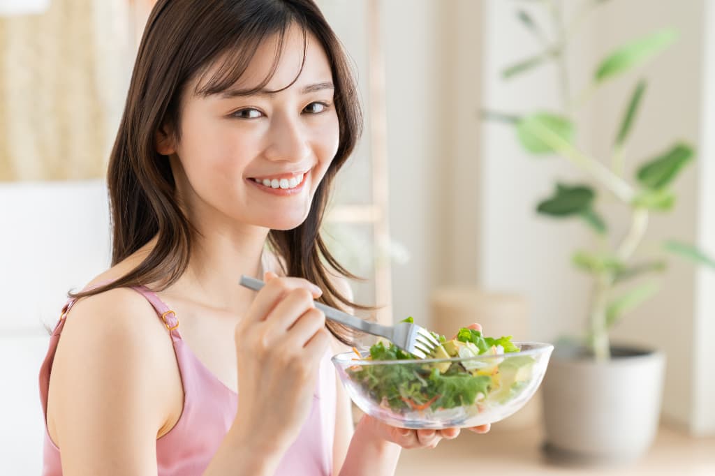 インプラントの治療を終え美味しく食事をいただく女性