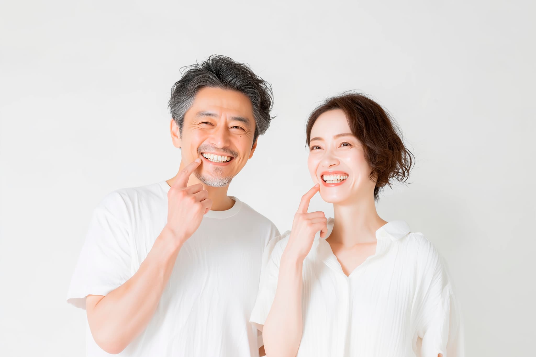 インプラントにした歯を指さす笑顔の夫婦