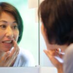歯周病になった歯ぐきを鏡を見る女性