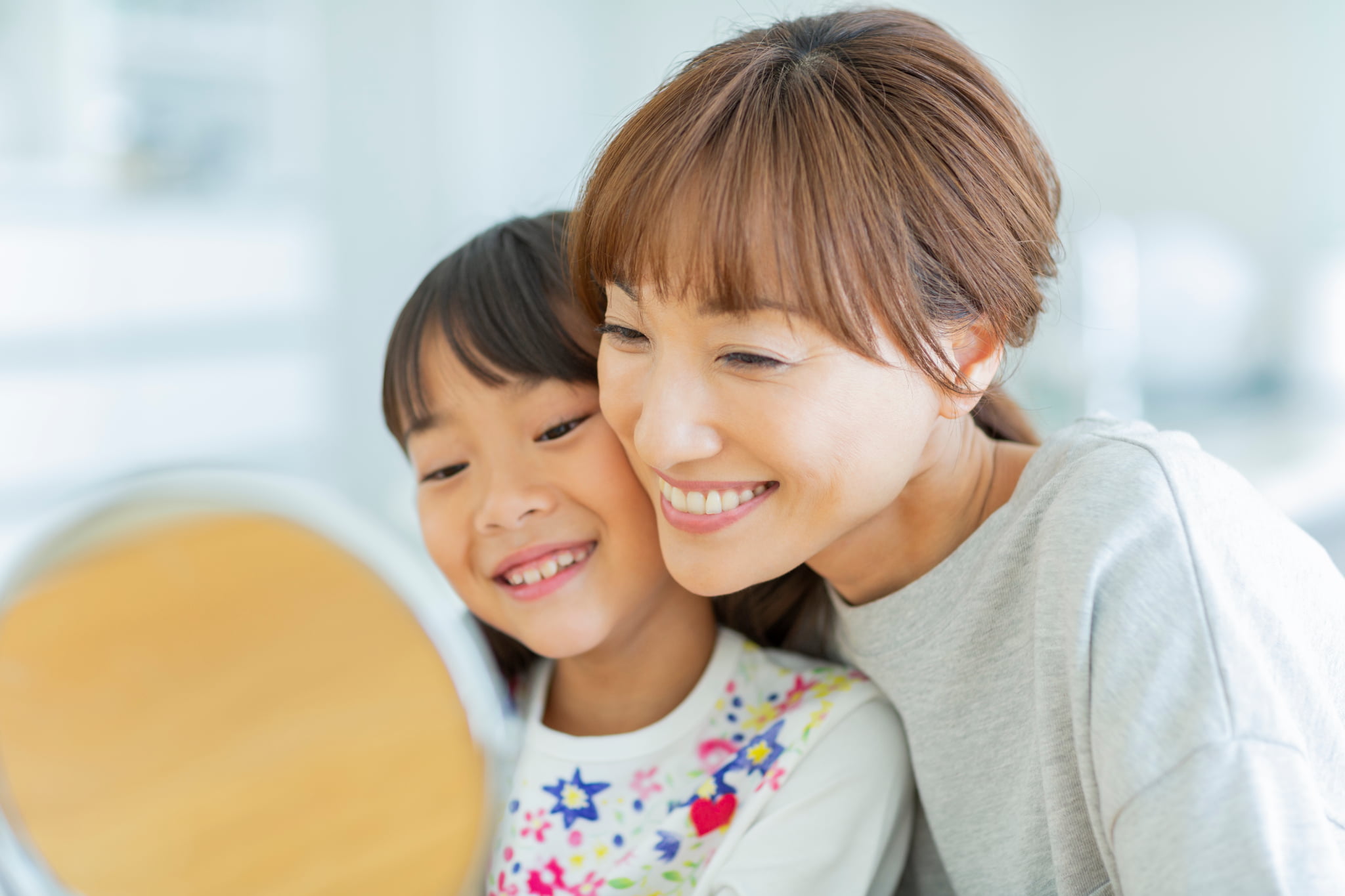 予防歯科を受診し美しくなった歯をチェックする親子