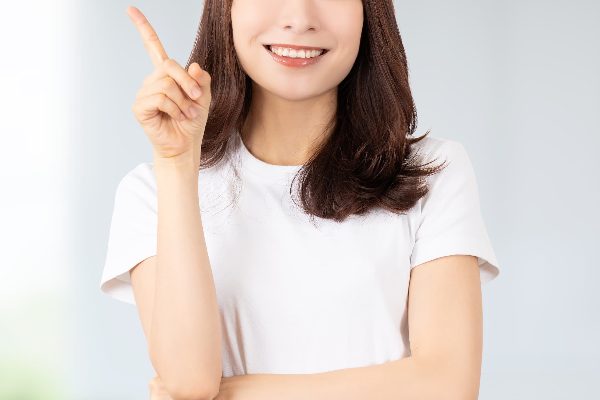 インプラント費用が高額になる理由を紹介する女性
