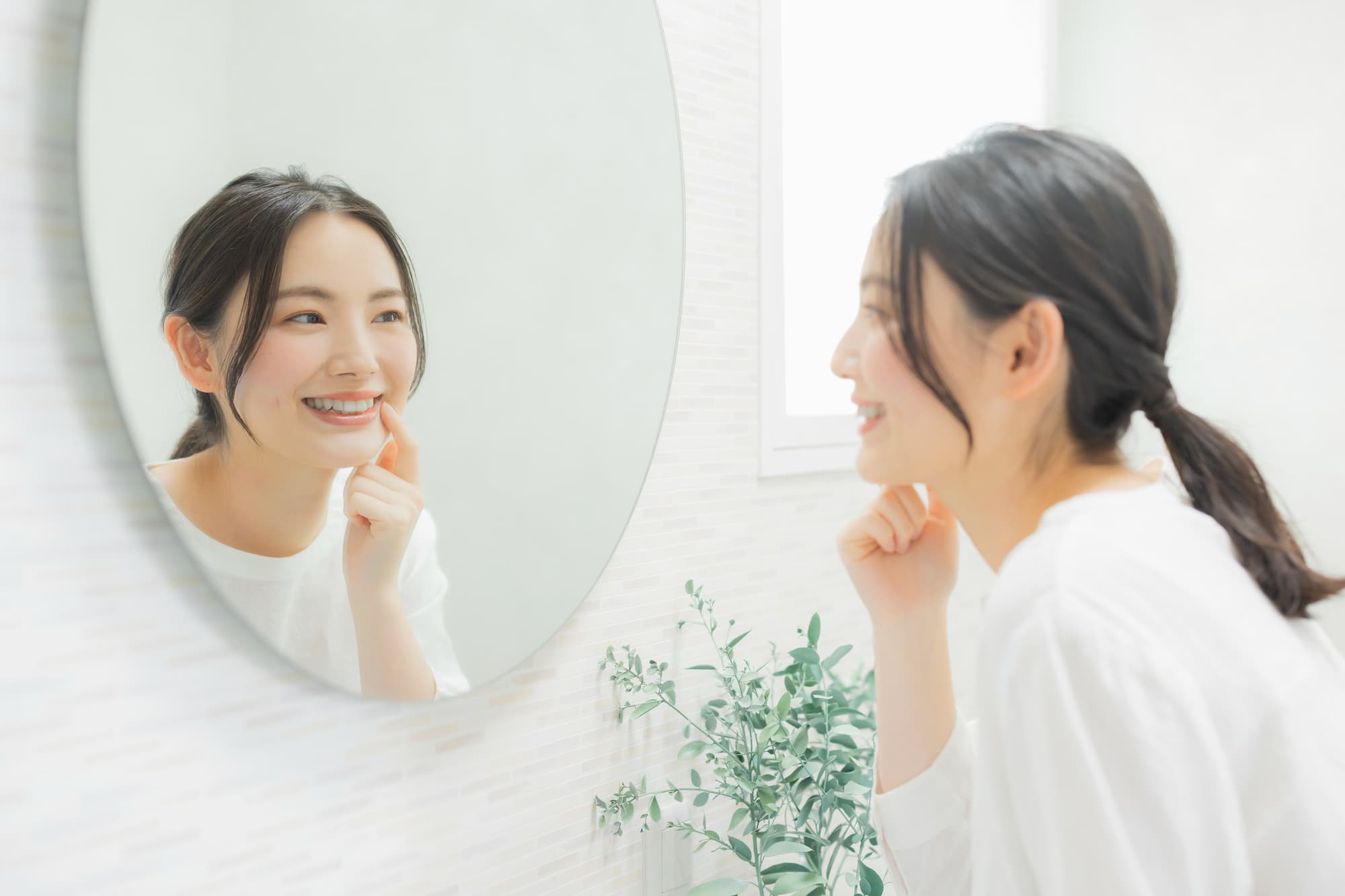 ブリッジ治療をした歯を鏡で確認する女性