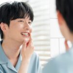 ホワイトニングした歯を鏡で見る男性