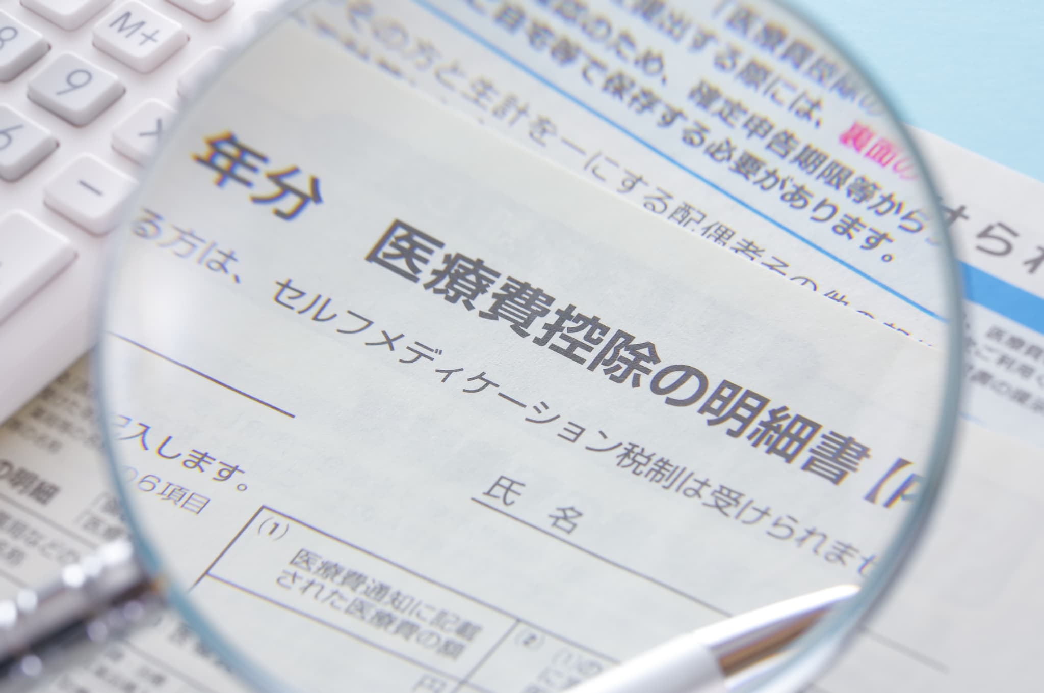 医療費控除の書類と虫眼鏡