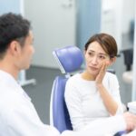 インビザラインで抜歯が必要か歯科医師に相談する不安そうな女性