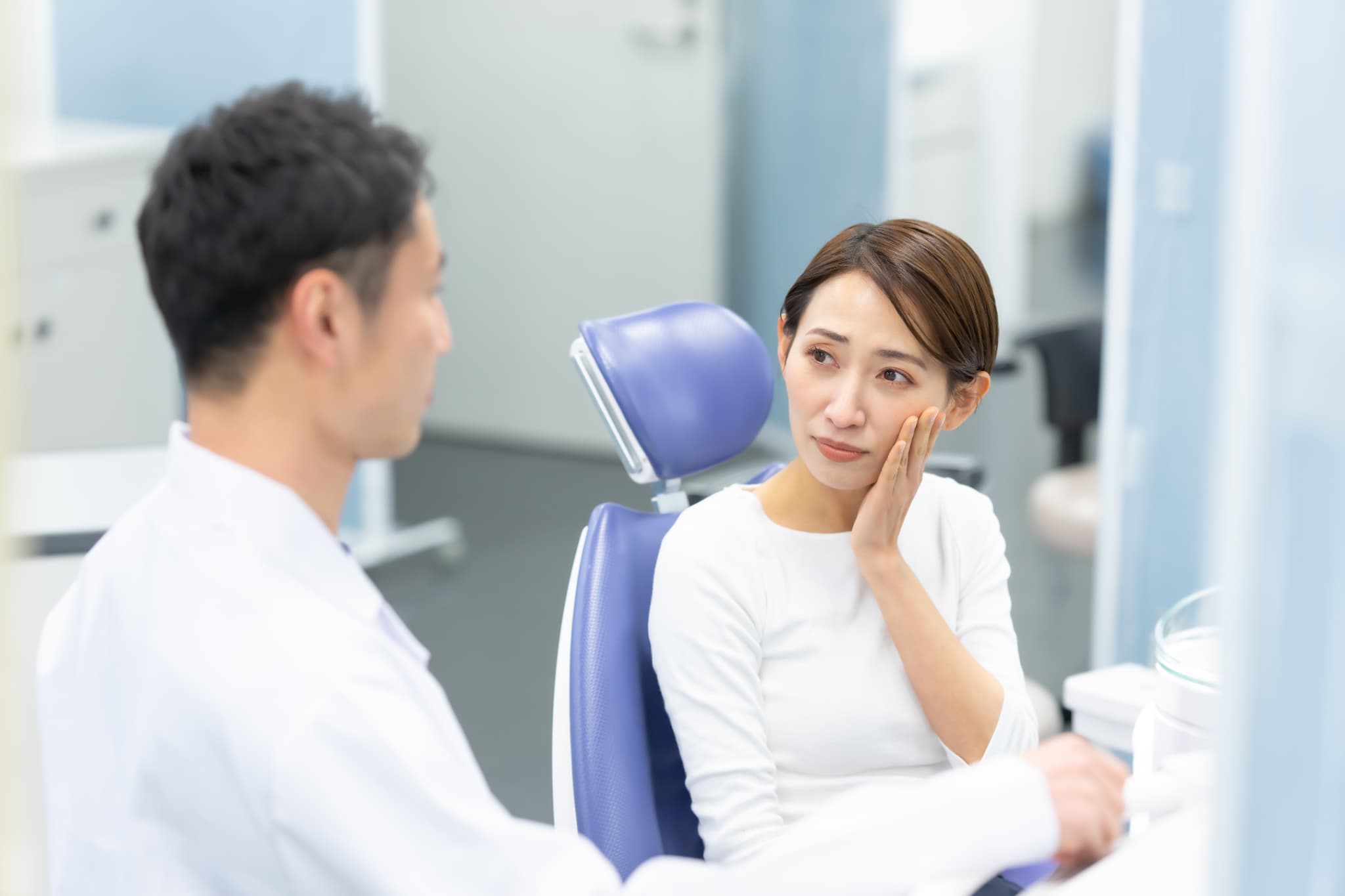インビザラインで抜歯が必要か歯科医師に相談する不安そうな女性