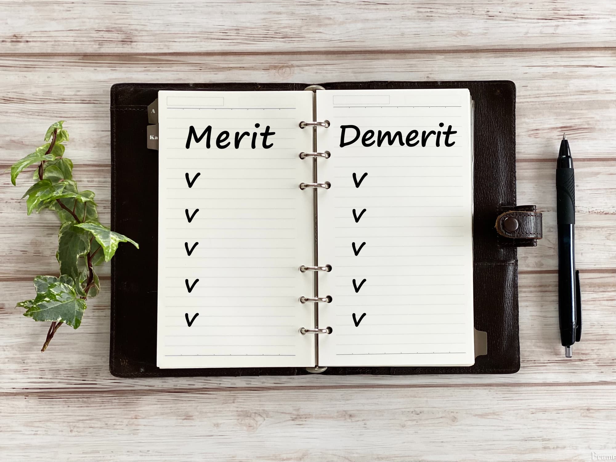 メリットデメリットと英語で書かれた手帳