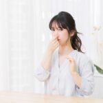自分の口臭に鼻をつまむ女性