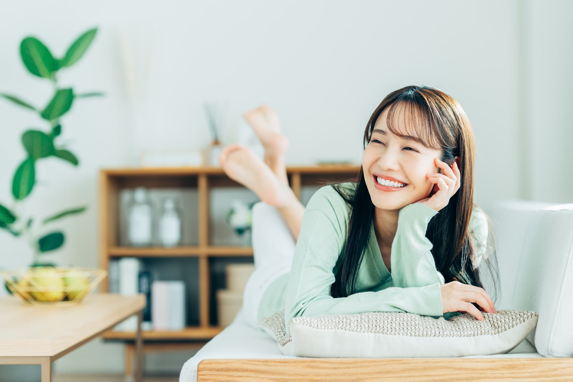 マウスピース矯正で美しい歯並びになった女性が部屋で寛いでいるイメージ